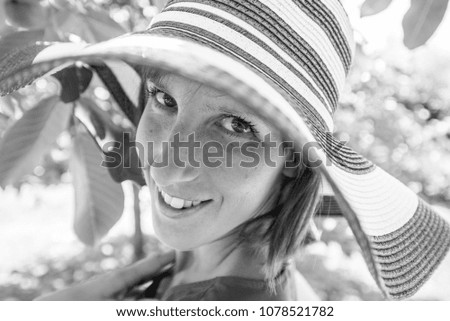 Similar – Young blonde woman portrait laughing outdoors sitting in a garden, and looking at camera.