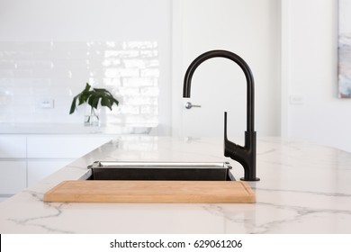 Monochrome kitchen detail of black gooseneck tap 