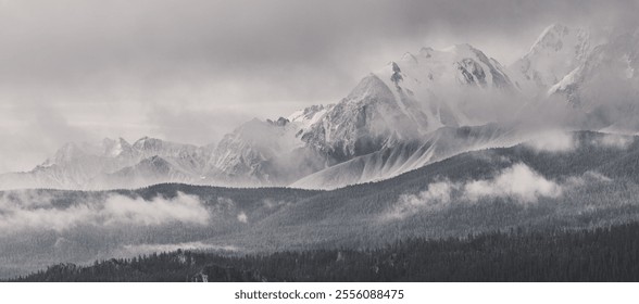 Monochrome landscape, snow-capped mountain peaks in clouds, traveling in the mountains, climbing - Powered by Shutterstock