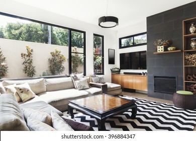 Monochrome living room with wood and grey tiling accents and chevron pattern rug