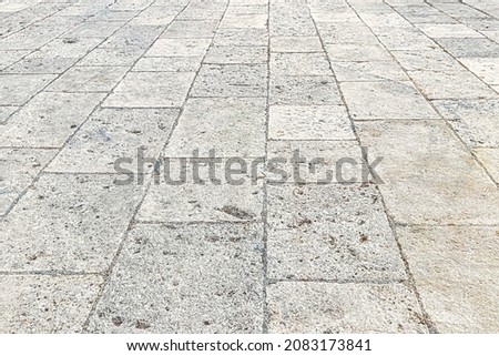 Monochrome old cobblestone pavement texture. Ancient sidewalk background.