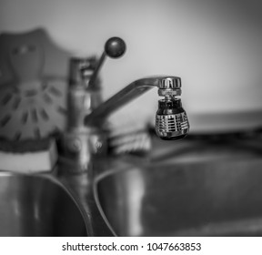 Monochrome photo of kitchen water tap with short depth of field and smooth out of focus bokeh.