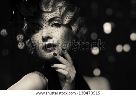 Monochrome picture of  elegant blond retro woman   wearing little hat with veil