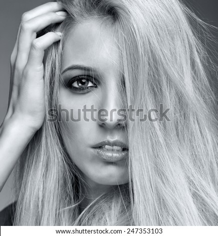 Retrato monocromo de una joven rubia de fondo gris