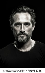 Monochrome Portrait Of Strong Mature Beardy Man. Male With Severe Look On His Face.