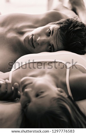 Similar – Young woman caressing man face lying over bed