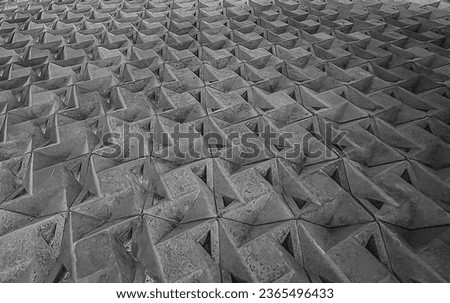 Monochrome textured pattern with folded triangular surfaces, ideal for abstract backgrounds, architectural surfaces, or 3D design