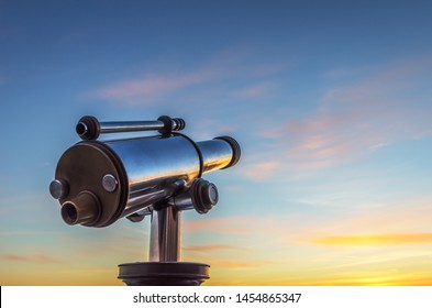 Monocular telescope at sunset with a cloudy sky