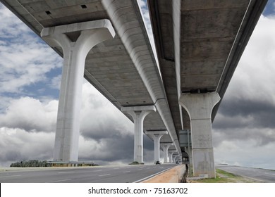 A monolith elevated twin highway traversing across a dramatic cloudy blue sky.