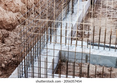 Monolithic foundation with metal reinforcement. Forms vertical formwork structures for the basement of a residential building. Monolithic concrete foundation. Support foundation. Home construction - Powered by Shutterstock