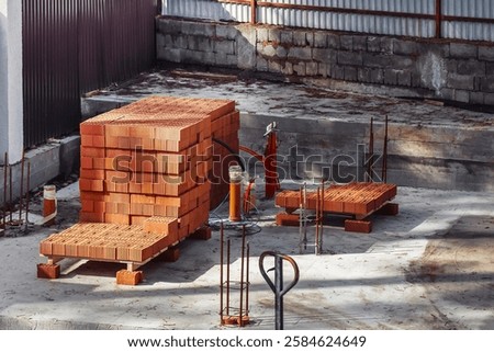 A monolithic slab foundation is being constructed in a wooded area with materials arranged nearby.