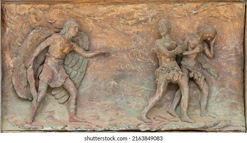 MONOPOLI, ITALY - MARCH 6, 2022: The bronze relief  Expulsion of Adam and Eve from Paradise the  on the gate of church Chiesa di Sacro Cuore by Wolfgang Stempfele from year 2002.