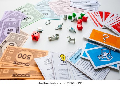 Monopoly Board Game, Playing Pieces, Houses And Cards On White Background