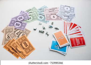 Monopoly Board Game, Playing Pieces And Cards On White Background