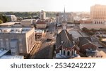 Monroe, Louisiana, USA - April 4, 2024: Afternoon sunlight shines on the historic buildings and church in the skyline of downtown Monroe.