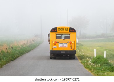 Monroe, WA, USA - April 29, 2021; A Monroe School Bus Drives Away Along A Rural Road On A Misty Spring Morning In The Snoqualmie Valley