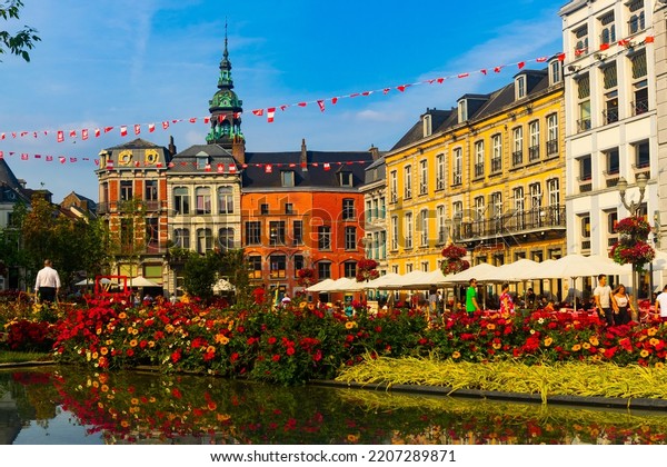 MONS, BELGIUM - August 04, 2022: Summer view of old\
houses and outdoor cafes on Grand Place, central square of Belgian\
city of Mons