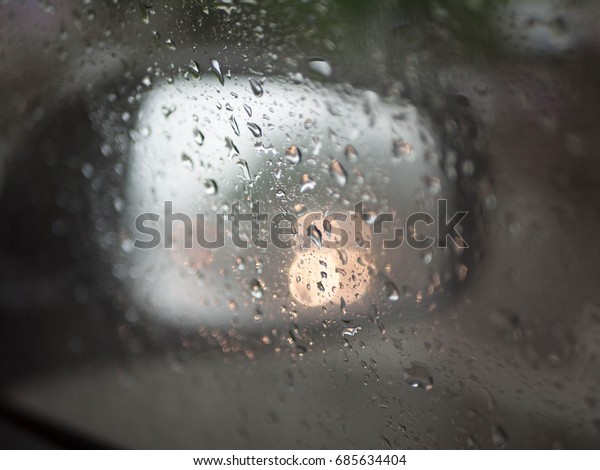 The Monsoon\
rain drops on the car\'s window\
glass.