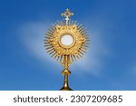 Monstrance for adoration in a Catholic church ceremony - Adoration of the Blessed Sacrament - religious symbol on blue background