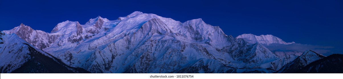Mont Blanc Massif at twilight with Alpine afterglow. Aiguille du Midi needle, Bossons Glacier, Mont Blanc mountain range. Chamonix, Haute-Savoie (74), Alps, France