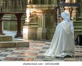 Mont Saint Michel, France _ June 20, 2019: Nun praying in the abbey at Mont Saint Michel