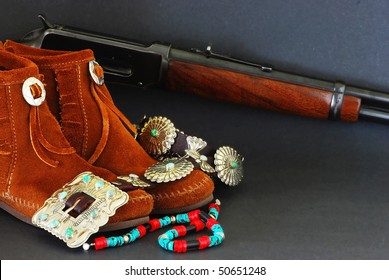 Montage Of Native American Turquoise And Silver Jewelry, Moccasins, And Winchester Rifle On Dark Background