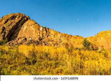 Montana Gold Butte With Moon High In Sky