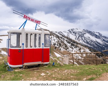 Monte Baldo, Italy. Red wagon of the old cable car, gondola lift, in the background the Monte Baldo mountain near Malcesine, Italy. Alpine landscape in summer. Europe - Powered by Shutterstock