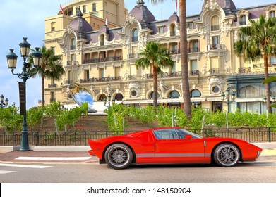 MONTE CARLO, MONACO - JULY 13: Red Sports Car And Hotel De Paris - Luxury Hotel Opened In 1863, Contains Rooms And Suites With Exclusive City And Sea Views In Monte Carlo, Monaco On July 13, 2013.