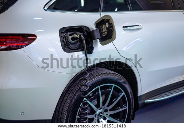 Monte-Carlo,\
Monaco 10.09.2020 Exhibition EVER E-Mobility. Power supply connect\
to electric vehicle for charge to the battery. Luxury white\
electrical car recharging. Selective\
focus