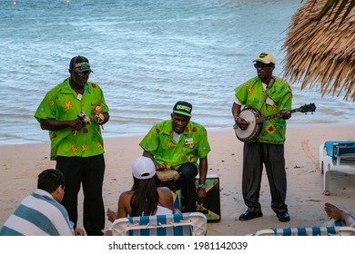 MONTEGO BAY, JAMAICA - JANUARY 09, 2017: Three Jamaican Musicians On The Beach Playing Mento - Jamaican Folk Music, They Play On Banjo, Hand Drums And Jamaican Congo Drums, Front View