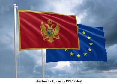 Montenegro and EU flag together next to each other on a flagpole. Montenegro flag in front of a European Union flag on a stormy sky background