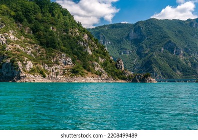 Montenegro. View of Lake Piva, located between the mountains. The lake is an artificial reservoir of fresh water. Bright blue sky with white clouds.Copy space.
