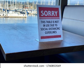 Monterey, CA - June 19, 2020: Sign On Table Inside Restaurant Stating That The Table Is Closed Due To Social Distancing Guidelines During The Covid 19 Pandemic. 