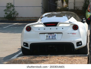 Monterey, CA, USA - Aug 14, 2021: A White, Luxury Lotus Car Parked Under A Tree During Classic Car Week In Monterey.  The Vanity License Plate Says M Bye.