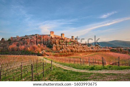 Monteriggioni, Siena, Tuscany, Italy: landscape at sunset of the ancient village along the Via Francigena with the medieval walls and the countryside with vineyards and olive trees

