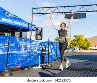 MONTGOMERY, ALABAMA - NOVEMBER 19, 2016: Older woman in great physical condition leaps in triumph and jubilation as she completes her very first 5k run at the Montgomery, Alabama Turkey Burner Run.