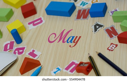 Month word may over wooden background with stationery 