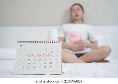 Monthly menstruation symptom period concept. Close up calendar marking on menstruation period day and woman have stomach pain as background.