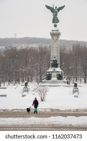 Montreal, CA - 12 December 2016: Woman With A Dog During Snow Storm, Near George-Étienne Cartier Monument On Mount Royal.