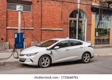 Montreal, CA - 16 May 2020: Chevrolet Volt electric car plugged into an EV charging station