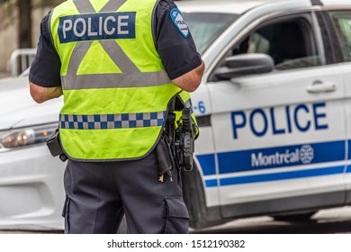 Montreal, Canada - 22 September 2019: Rear View Of A Policeman In Front Of A Police Car.