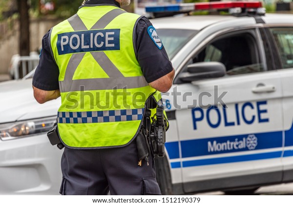 Montreal, Canada - 22 September 2019: Rear\
view of a policeman in front of a police\
car.
