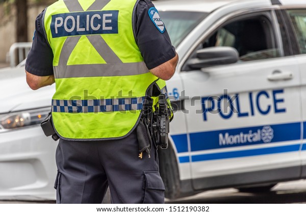 Montreal, Canada - 22 September 2019: Rear\
view of a policeman in front of a police\
car.