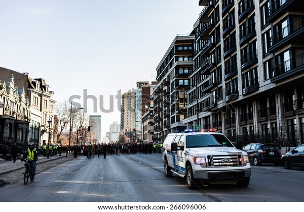 MONTREAL, CANADA  \
APRIL 02 2015: Riot in the Montreal Streets to counter the Economic\
Austerity Measures. Police Pick-up Truck in front of the Protesters\
controlling the\
Traffic