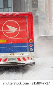 MONTREAL, CANADA - Jan 19, 2022: A Vertical Shot Of Canada Post Truck Leaving Its Parking Spot During A Snow Storm