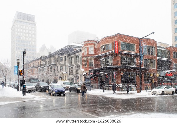 Montreal, Canada -\
january 2020: Crossroad of De Maisoneuve boukevard and Crescent\
street under a heavy\
snow