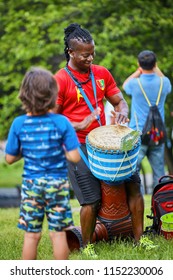 Montreal, Canada - June, 2018. African percussionist plays djembe drum bongo and a kid watches him at Mount Royal Park, Montreal, Quebec, Canada. Editorial.