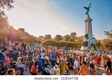 Montreal, Canada - June, 2018: Ethnically diversified crowd gathered and cheering around the monument of Sir George Etienne Cartier in mount royal or tam tams park.
