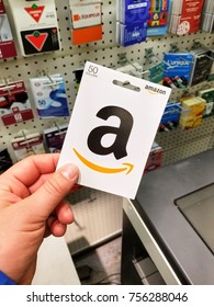 MONTREAL, CANADA - NOVEMBER 7, 2017: 50 dollar Amazon gift card in a hand on gift cards background. Amazon is an American electronic commerce and cloud computing company based in Seattle, Washington